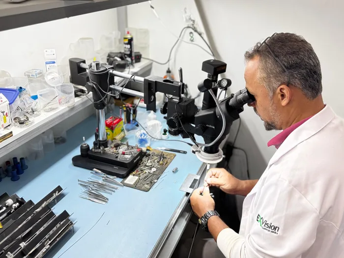 Técnico realizando manutenção de precisão em óptica cirúrgica